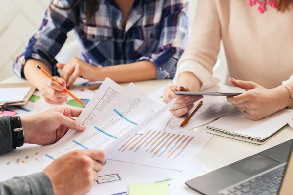 Group of professionals collaborating on paperwork at a conference table.